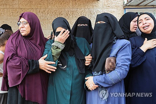 18일(현지시간) 가자지구 데이르 알발라의 알아크사 순교자 병원에서 팔레스타인 여성들이 공습에 사망한 이들을 애도하고 있다.      [데이르알발라 로이터=연합뉴스]